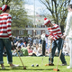 Students dressed in all white compete against students dressed in Where's Waldo garb in a competitive game of croquet at St John's College